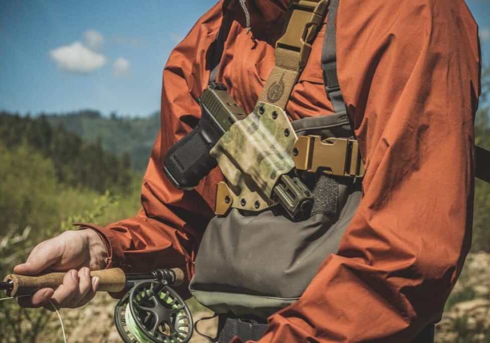 Fly fisherman wearing the GunfightersINC Kenai Chest Holster.