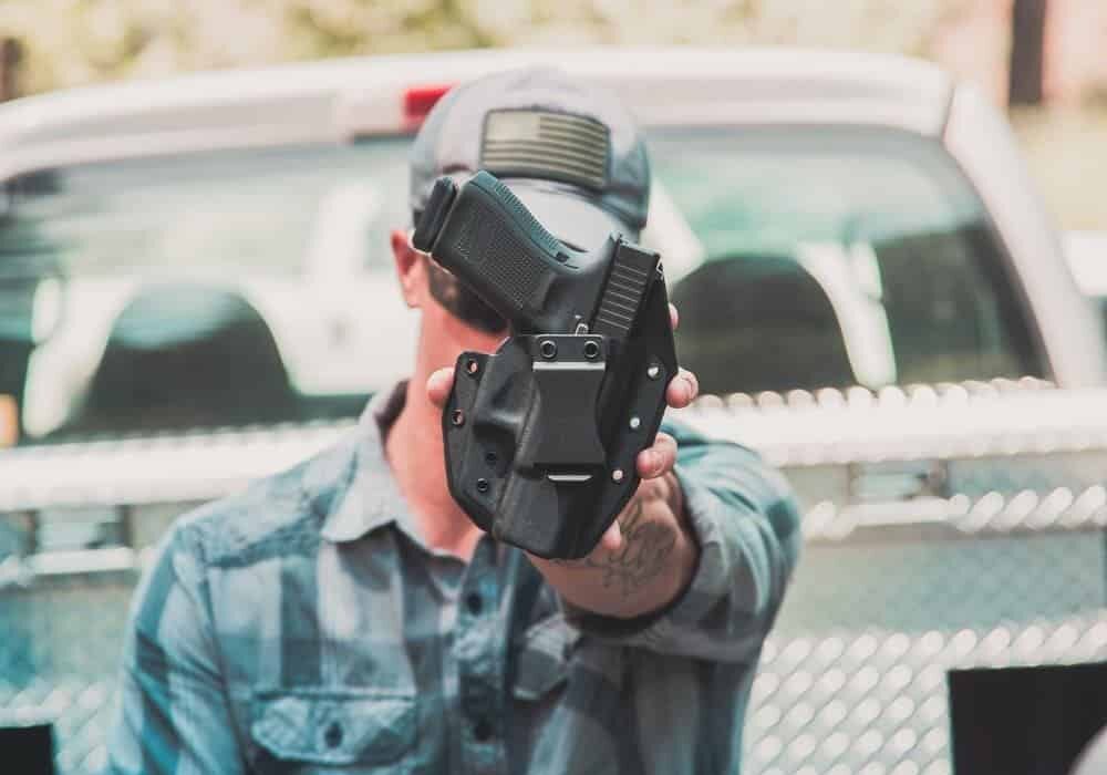Man holding up the Solace IWB Concealment Holster from GunfightersINC.