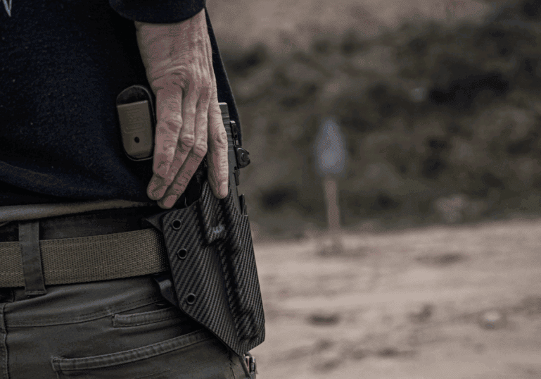 A man at the range using a GunfightersINC Ronin OWB Holster.