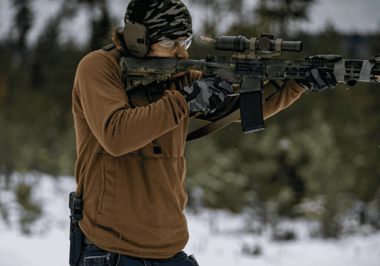 A man shooting a rifle at the shooting range.