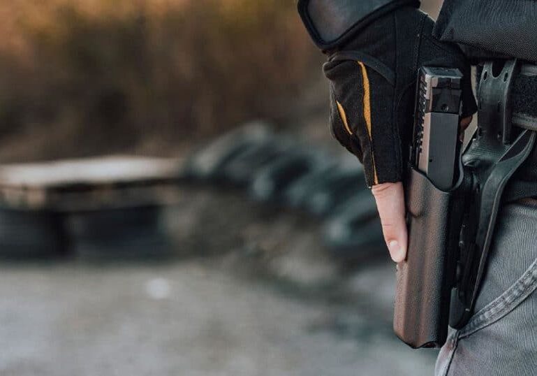 man-holding-gun-in-holster