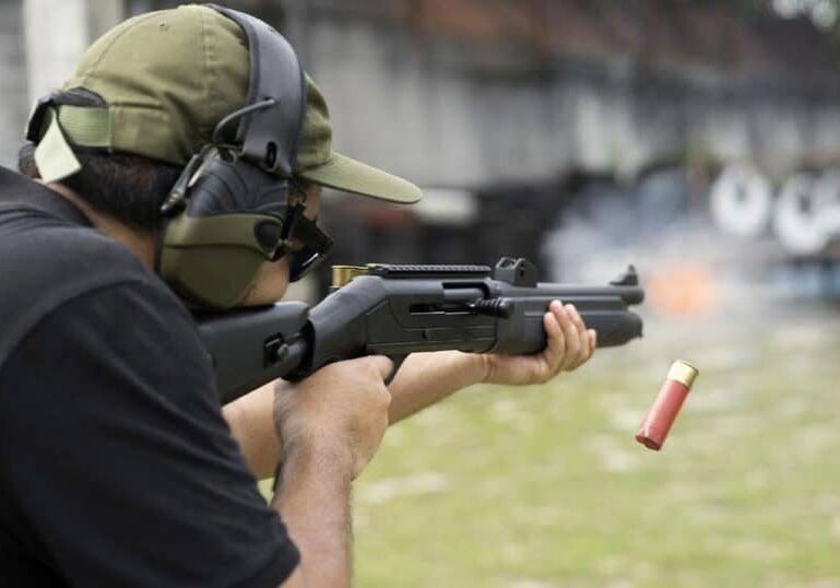 man-wearing-ear-protection-fring-shotgun