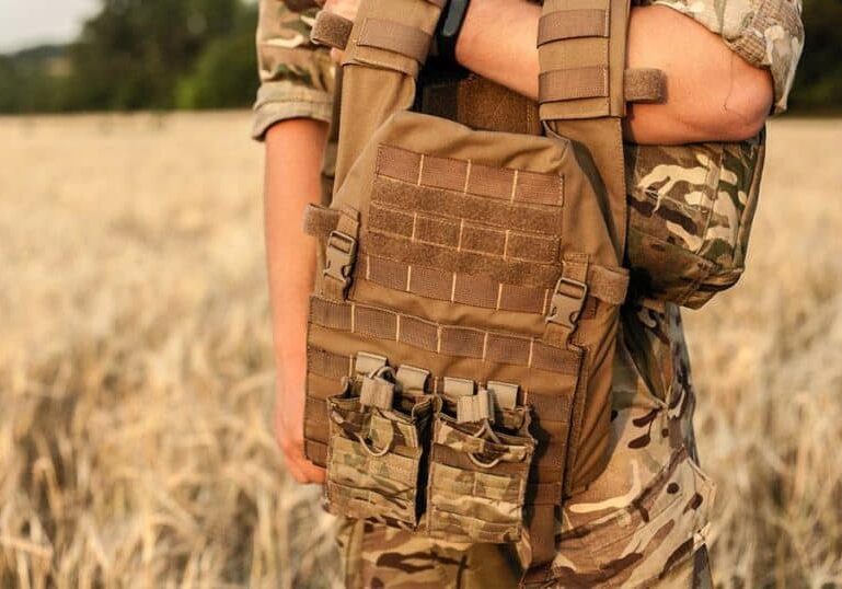 soldier-holding-tactical-camo-vest