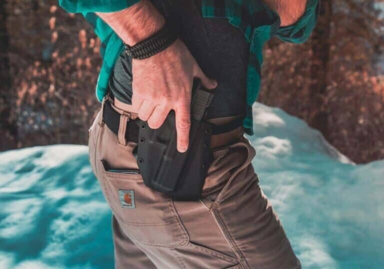 man's hand ready to draw weapon from his owb holster